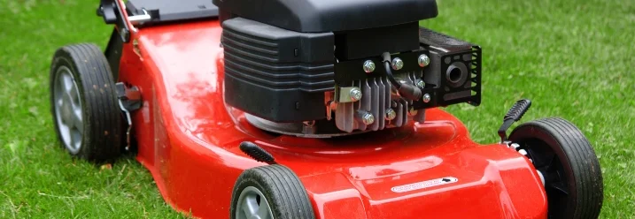 Roter Rasenmäher auf grünem Rasen